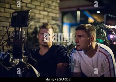 Hinter den Kulissen. Der Filmregisseur überwacht und steuert die Aufnahme des Films auf dem lcd-Display vom Filmmontagestudio im Freien aus. Analog A Stockfoto