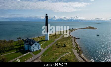 Sõrve säär, Saaremaa, Estland - 23. August 2021: Spitze des Kaps von Sõrve mit Leuchtturm von Sõrve und magisch bewölktem Himmel. Luftdrohnenfoto in Saaremaa Sõrve Stockfoto