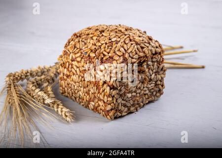 Vollkornbrot mit Weizen, Roggen und Sonnenblumenkernen auf einem grauen Holzbrett Stockfoto