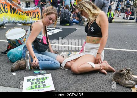 London, Großbritannien. August 2021. Eine Aktivistin, die ihren Körper während der Demonstration malen ließ. Klimaaktivisten von Extinction Rebellion demonstrieren in der Parliament Street, Westminster, bei der Impossible Rebellion. XR Cymru demonstrierte aktiv gegen die Beteiligung der Regierung an der fossilen Energiewirtschaft in Whitehall. Kredit: SOPA Images Limited/Alamy Live Nachrichten Stockfoto