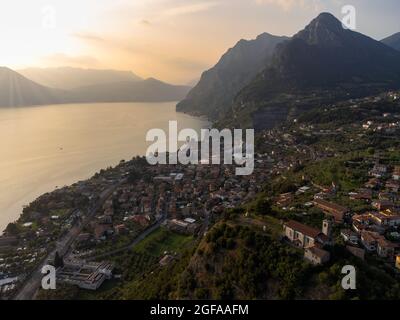 Luftpanorama einer kleinen Stadt mit Blick auf die Seenlandschaft bei Sonnenuntergang, See Iseo, Lombardei, Italien Stockfoto