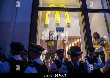 LONDON, ENGLAND - 24 2021. AUGUST, Extinction Rebellion's Animal Rebellion Demonstranten übernehmen McDonald's auf dem Leicester Square Stockfoto