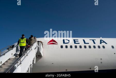 Ramstein Miesenbach, Deutschland. August 2021. Afghanische Flüchtlinge besteigen ein Delta A350-Verkehrsflugzeug, um nach der Evakuierung von Kabul auf dem Ramstein Air Base am 24. August 2021 in Ramstein-Miesenbach an einen anderen Ort zu überführen. Im Rahmen der Zivilreserve-Luftflotte rief das US-amerikanische Luftverkehrsunternehmen United Airlines, American Airlines, Delta Air und Hawaiian Airlines 18 zivile Flugzeuge auf, um im Rahmen der Operation Allies Refuge bei der Verlegung von Evakuierten zu helfen. Quelle: Planetpix/Alamy Live News Stockfoto