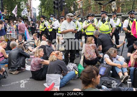 Cambridge Circus, London, Großbritannien. August 2021. Die Demonstranten vom Aussterbungsaufstand sitzen am Cambridge Circus und blockieren die Charing Cross-Straße auf dem Weg zum Trafalgar Square. Quelle: Xiu Bao/Alamy Live News Stockfoto