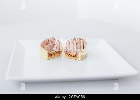 Ein Stück Shortbread-Tartlet, eclair, Kuchen mit in zwei Hälften geschnittenem Sahnehäubchen, in einer köstlichen Füllung Stockfoto