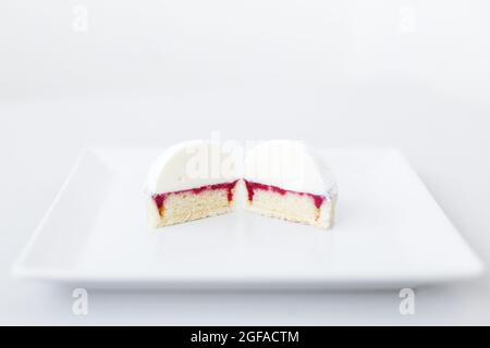 Ein Stück Shortbread-Tartlet, eclair, Kuchen mit in zwei Hälften geschnittenem Sahnehäubchen, in einer köstlichen Füllung Stockfoto