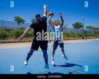Sportlich attraktive spanische Basketballspieler trainieren auf einem Basketballplatz Stockfoto