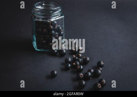 Frische Blaubeeren in einem Glas auf einem schwarzen Brett. Heidelbeeren für eine gesunde Ernährung und Vegetarier Stockfoto