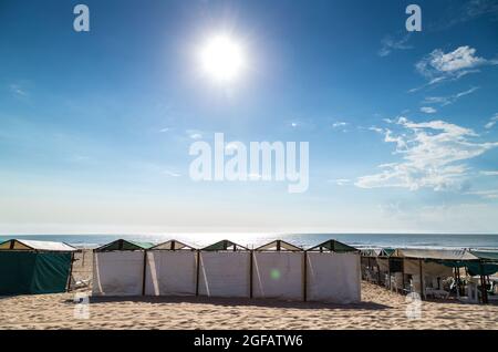 Der Strand am Morgen. Strandzelte im Vordergrund. Sonniger Sommertag. Szene der südatlantikküste. MAR DE LAS PAMPAS, ARGENTINIEN Stockfoto