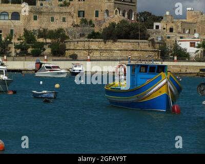 BIRZEBBUGA, MALTA - 30. März 2014: Die bunten kleinen Fischerboote, die mit Bojen in der St. George's Bay in Birzebbuga, Malta, festgemacht sind. Stockfoto