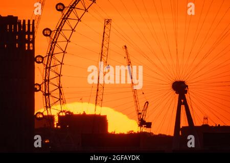 London, Großbritannien. August 2021. Wetter in Großbritannien: Dramatische Abendsonne geht in der Nähe des Riesenrads des London Eye unter, das von der Spitze des Greenwich Parks aus gesehen wird. Kredit: Guy Corbishley/Alamy Live Nachrichten Stockfoto