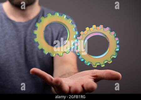 Hand, die einen schwebenden Render großer Zahnräder hält Stockfoto