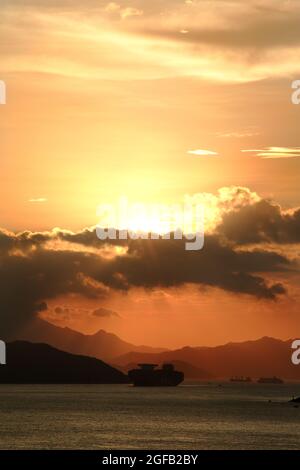 Schöner Blick auf das Meer, das unter dem Sonnenuntergang im wolkigen blauen Himmel schimmert Stockfoto