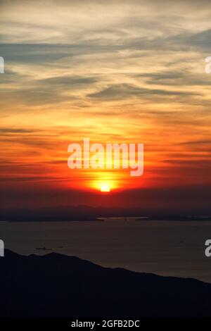 Schöner Blick auf das Meer, das unter dem Sonnenuntergang im wolkigen blauen Himmel schimmert Stockfoto