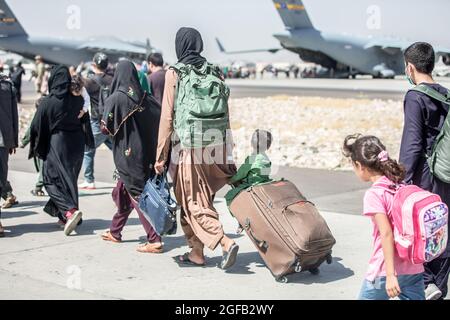 Ein Kind schaut auf das Flugzeug, während es während einer Evakuierung am Hamid Karzai International Airport, Kabul, Afghanistan, im August 24, auf seinen Flug zuläuft. US-Dienstmitglieder unterstützen das Außenministerium bei einer geordneten Abseichung von designiertem Personal in Afghanistan. (USA Marine Corps Foto von Sgt. Samuel Ruiz). Stockfoto