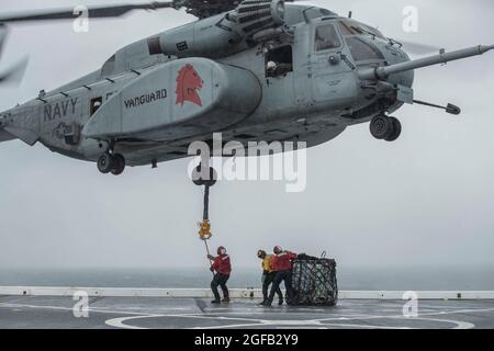 210814-N-YP246-1075 PAZIFISCHER OZEAN (AUG 14, 2021) Seeleute üben eine vertikale Auffüllung mit einem MH-53E Sea Dragon Hubschrauber der Helicopter Mine Gegenmaßnahmen Squadron Fourteen (HM) 14 an Bord des amphibischen Transportschiffes USS Green Bay (LPD 20). Green Bay, Teil des Amphibiengeschwaders 11, ist im Verantwortungsbereich der 7. US-Flotte tätig, um die Interoperabilität mit Verbündeten und Partnern zu verbessern und als einsatzbereite Einsatztruppe für den Frieden und die Stabilität in der Indo-Pazifik-Region zu dienen. (USA Navy Foto von Mass Communication Specialist 2nd Class Darcy McAtee/veröffentlicht) Stockfoto