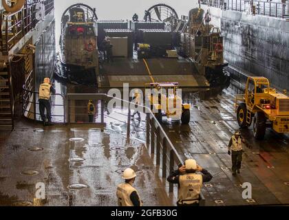 210813-N-YP246-1150 PAZIFISCHER OZEAN (AUG 13, 2021) Seeleute entladen Kisten vom Landing Craft Air Cushion (LCAC) 29, das der Naval Beach Unit (NBU) 7 zugewiesen wurde, im Brunnendeck des Amphibientransportschiffes USS Green Bay (LPD 20). Green Bay, Teil des Amphibiengeschwaders 11, ist im Verantwortungsbereich der 7. US-Flotte tätig, um die Interoperabilität mit Verbündeten und Partnern zu verbessern und als einsatzbereite Einsatztruppe für den Frieden und die Stabilität in der Indo-Pazifik-Region zu dienen. (USA Navy Foto von Mass Communication Specialist 2nd Class Darcy McAtee/veröffentlicht) Stockfoto