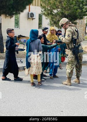 1. LT. Michelle Jaeger, Zugführer der A Company der Minnesota National Guard, 1. Kombiniertes Waffenbataillon, 194. Rüstungsregiment, interagiert am 21. August 2021 im Rahmen der Operationen am Hamid Karzai International Airport mit afghanischen Kindern. Soldaten aus Minnesota leisten humanitäre Hilfe für US-Bürger, Visa-Inhaber von Sondereinwanderern und ihre Familien. Etwa 1,100 Soldaten der Task Force 1-194 waren Anfang 2021 für eine neunmonatige Mission zur Unterstützung der Operation Spartan Shield in den Nahen Osten entsandt. Im Einsatz übernahmen die Soldaten die Verantwortung innerhalb des Militärs Stockfoto