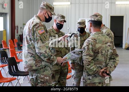 U.S. Army LT. General Donnie Walker, Mitte links, stellvertretender Generalkommandant des U.S. Army Maternel Command und der leitende Kommandeur im Redstone Arsenal, Alabama, diskutiert die Lage der Wohngebiete, die von Afghanen während ihres Aufenthalts in Fort McCoy, Wisconsin, genutzt werden, 23. August 2021. Das Verteidigungsministerium stellt zur Unterstützung des Außenministeriums Transportmittel und provisorische Unterkünfte zur Verfügung, um die Operation Allies Refuge zu unterstützen. Diese Initiative geht auf das Engagement Amerikas für afghanische Bürger zurück, die den Vereinigten Staaten geholfen haben, und bietet ihnen wesentliche Unterstützung an sicheren Orten Stockfoto