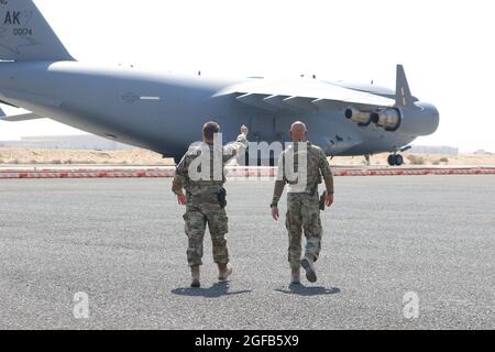 Zwei US-Luftstreitkräfte, die dem 386. Air Expeditionary Wing zugewiesen wurden, gehen auf den ersten C-17-Flug, der Afghanen in Sicherheit in Kuwait auf dem Luftwaffenstützpunkt Ali Al Salem in Kuwait transportiert. Obwohl die Operation vom Außenministerium geleitet wird, wurde das Verteidigungsministerium mit der Unterstützung von Transport, Sicherheit, Logistik und medizinischer Unterstützung für Inhaber von Sondereinreisevisa an verschiedenen Orten beauftragt, wo sie vor der Ankunft am endgültigen Bestimmungsort einen strengen Papierkraftakkkzur durchlaufen werden. Bis heute haben Mitarbeiter des Verteidigungsministeriums bei der Einbringung von mehr als unterstützt Stockfoto