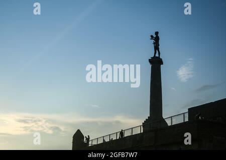 Bild der ikonischen Siegesstatue auf der Belgrader Festung Kalemegdan mit einer Gruppe von Touristen, die vor ihr stehen. Pobednik ist ein monumen Stockfoto