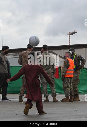 Ein afghanisches Kind spielt mit einem Ball während der Operation Allies Refuge auf dem Ramstein Air Base, Deutschland, 22. August 2021. Spielzeuge wie Kugeln, Stofftiere und Action-Figuren wurden von Mitgliedern der Kaiserslauterer Militärgemeinde gespendet. (USA Luftwaffe Foto von Senior Airman Caleb S. Kimmell) Stockfoto