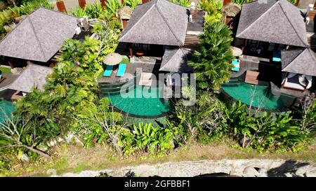 Drone Luftaufnahme des Luxushotels mit Strohdachvillen und Pools in tropischem Dschungel und Palmen. Luxuriöse Villa, Pavillon im Wald, Ubud, Bali. Stockfoto
