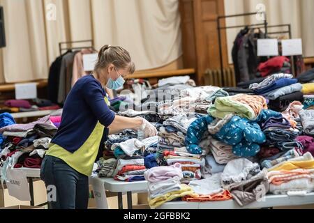 Lille, Frankreich. August 2021. Ein Mitarbeiter sorgt für Kleidung und andere tägliche Bedarfsgegenstände, die von Einheimischen an afghanische Flüchtlinge gespendet werden, die von der Stadt Lille im Norden Frankreichs am 24. August 2021 empfangen wurden. Quelle: Sebastien Courdji/Xinhua/Alamy Live News Stockfoto