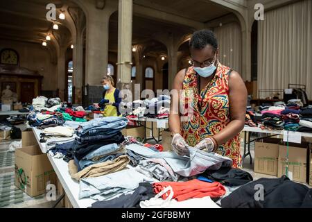 Lille, Frankreich. August 2021. Die Mitarbeiter organisieren Kleidung und andere tägliche Notwendigkeiten, die von den Einheimischen an afghanische Flüchtlinge gespendet werden, die von der Stadt Lille im Norden Frankreichs am 24. August 2021 empfangen wurden. Quelle: Sebastien Courdji/Xinhua/Alamy Live News Stockfoto