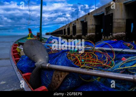 Ein thailändisches Fischerboot mit Ausrüstung steht an einem Betonsteg in Hua hin, Thailand, vertäut. Stockfoto