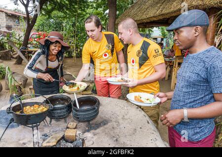 Johannesburg Südafrika, Soweto Lebo's Backpackers Hostel, Schwarze Frau weibliche Kochkessel serviert Mittagessen Mann Männer männlich, Stockfoto