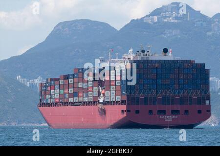 Containerschiff „San Fernando“, (Reg. Marshallinseln), im East Lamma Channel, Mt Kellett, Hong Kong im Hintergrund, Hong Kong China 22. August 2021 Stockfoto