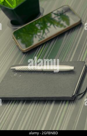 Stift und Notizbuch auf dem Bürotisch. Tabellenansicht von oben. Unternehmenshintergrund. Stockfoto