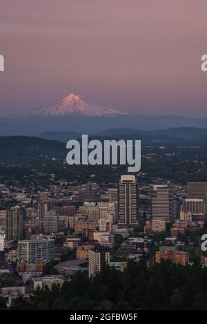 Mt Hood bei Sonnenuntergang über der Stadtlandschaft von Portland, Oregon Stockfoto