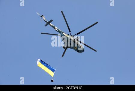 Nicht exklusiv: KIEW, UKRAINE - 24. AUGUST 2021 - Hubschrauber trägt die Nationalflagge der Ukraine während der feierlichen Militärparade am 30 Stockfoto