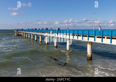 Zelenogradsk, Russland - 6. August 2021: Die Menschen gehen an der blauen Seebrücke entlang, an der Ostseeküste Stockfoto