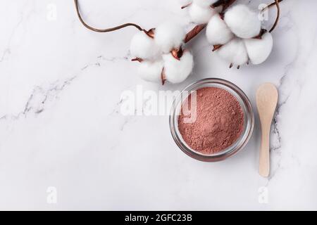 Trockenes rotes Tonpulver im Gesicht in einer Schüssel, Draufsicht. Natürlicher organischer kosmetischer Ton für Schönheitsbehandlungen. Stockfoto