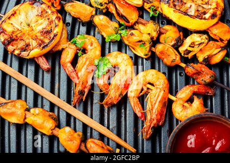 Auf einem Holzstock gebratene Kebab-Garnelen.gegrillte Scampi Stockfoto