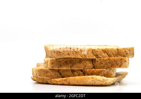 Isolierter Stapel Vollkornbrot auf weißem Hintergrund. Nahaufnahme, Seitenansicht von braunem Vollkornbrot, Low-Angle-Ansicht. Stockfoto