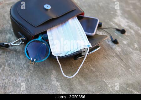 Dinge aus offener Lady Handtasche. Konzept zum Schutz vor COVID-2019. Stockfoto