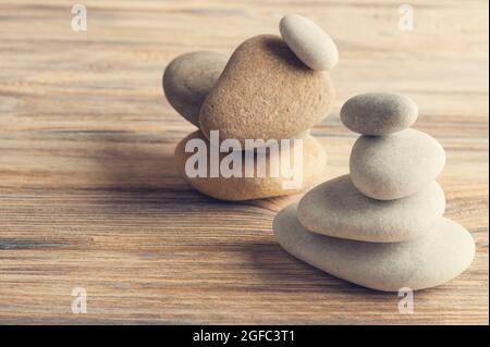 Schöne Zen-Komposition mit Steinen auf schäbigen Holzhintergrund. Getönter Jahrgang Stockfoto