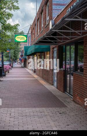 Syracuse, New York - 1. Juli 2021: Vertikale Ansicht des Bürgersteiges der Marshall Street mit J-Michael-Schuheschild im Hintergrund. Stockfoto