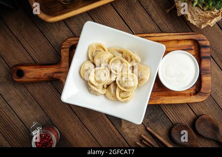 Russische Pelmeni-Knödel mit saurer Rahm Stockfoto