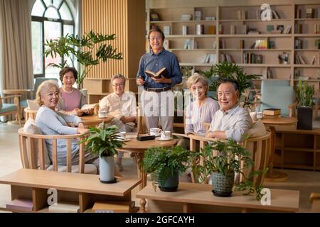 Älterer Erwachsener, der im Buchclub ein Buch diskutiert Stockfoto