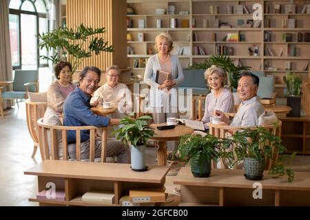 Älterer Erwachsener, der im Buchclub ein Buch diskutiert Stockfoto