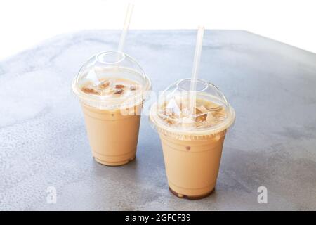 Zwei Eiskaffee oder Latte in einer Plastikbecher zum Mitnehmen auf dem Steintisch des Straßencafés Stockfoto