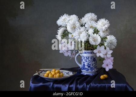 Stillleben mit Strauß von Astern und Pflaumen Stockfoto