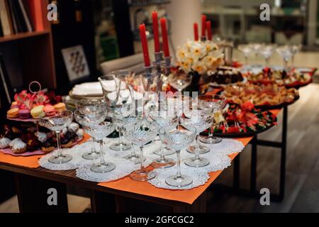 Vorbereitung auf Bankette oder Partys. Weingläser, Snacks und Desserts. Wunderschöne festliche Tischkulisse. Stockfoto