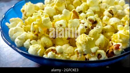 Frisches Popcorn in einer blauen Schüssel auf einem Holztisch