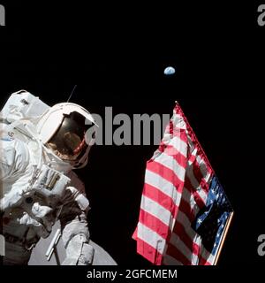 (7-19. Dez. 1972) --- der Wissenschaftler-Astronaut Harrison H. Schmitt, Mondmodulpilot, wird bei der Mondlandeaktivität (EVA) auf der Taurus-Littrow-Landestelle neben der US-Flagge fotografiert. Der höchste Teil der Flagge scheint im fernen Hintergrund auf unseren Planeten Erde zu zeigen Stockfoto